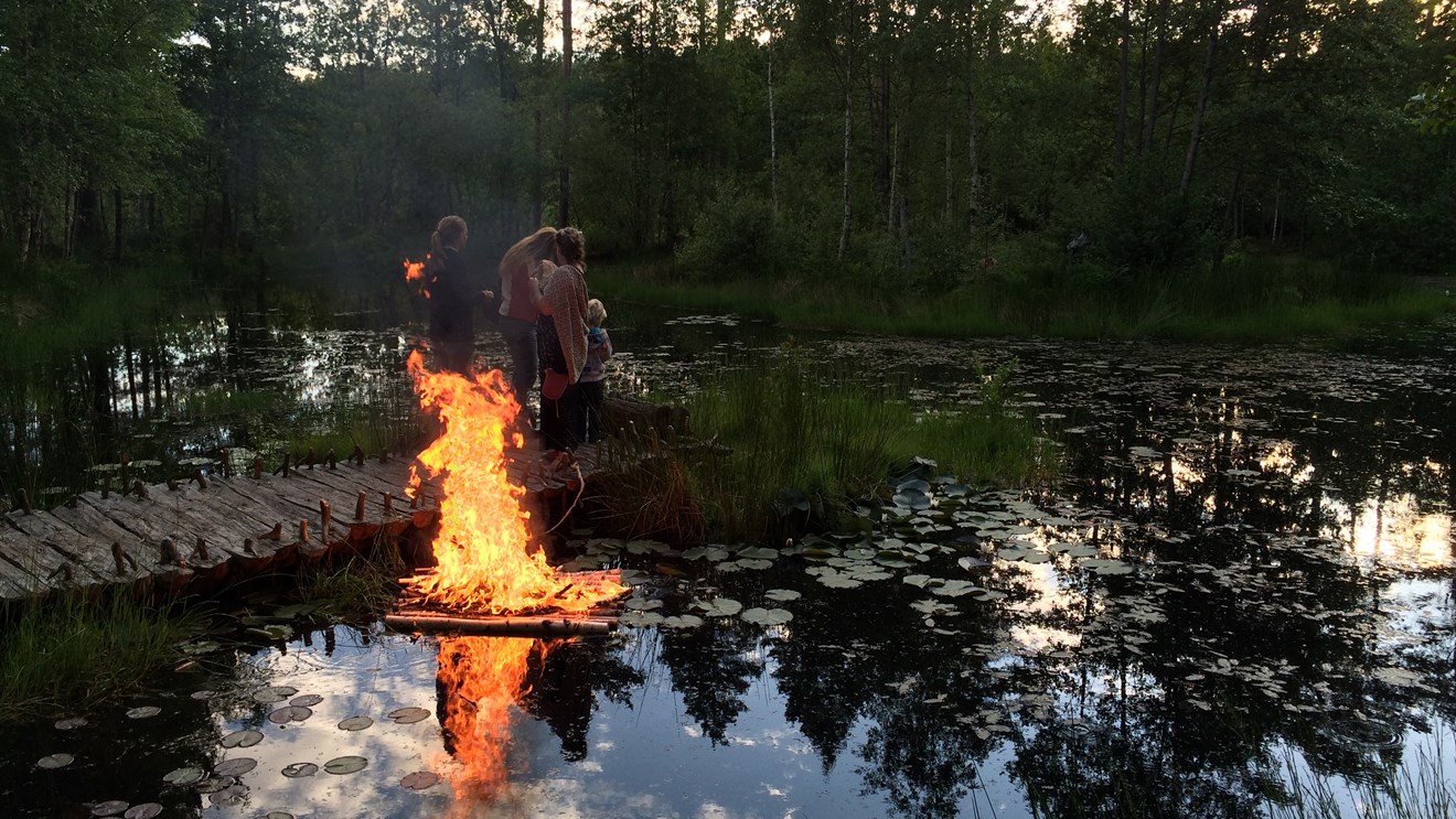 En eld som brinner på en vattenytan till en liten sjö
