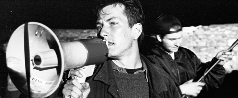 En man som talar i en megafon på en filminspelning